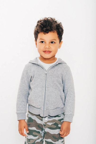 Studio shot of handsome african toddler boy wearing grey hoody, posing on white background - Photo, Image