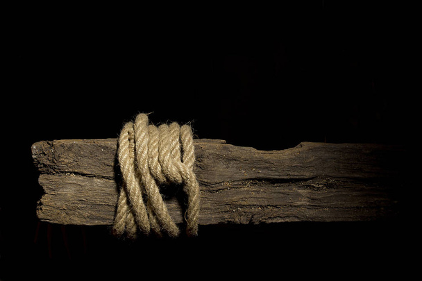 Rope on an old rotten wooden crossbeam - Foto, imagen