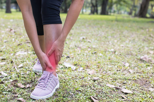women has leg pain as exercise in park - Photo, Image
