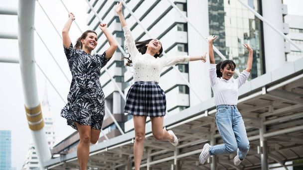 Gente alegre, diversidad joven salto femenino, concepto de ciudad
 - Foto, imagen