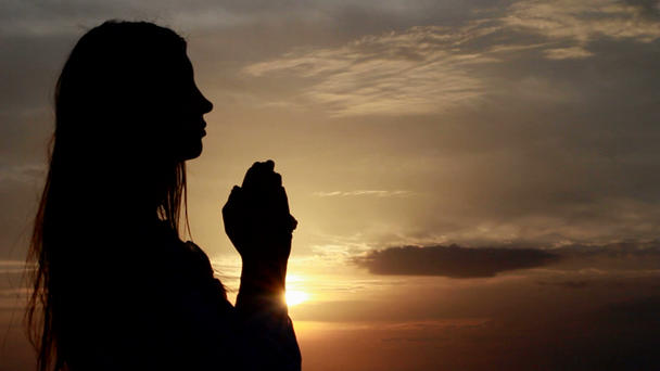 ima. asszony kezével hajtva a tengerparti naplemente alatt. - Felvétel, videó