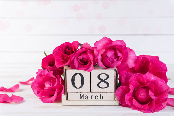 Concept de la Journée internationale de la femme. Roses roses avec le 8 Mars texte sur calendrier bloc en bois sur fond blanc en bois
. - Photo, image