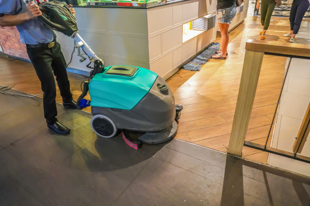 vloer reinigen machine werd gewerkt door werknemer en huis houden, in de foodcourt van departmentstore. - Foto, afbeelding
