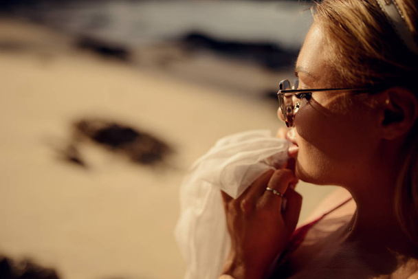 fashion photo of beautiful woman in glasses with a handkerchief in her hands on the beach in Thailand - Φωτογραφία, εικόνα