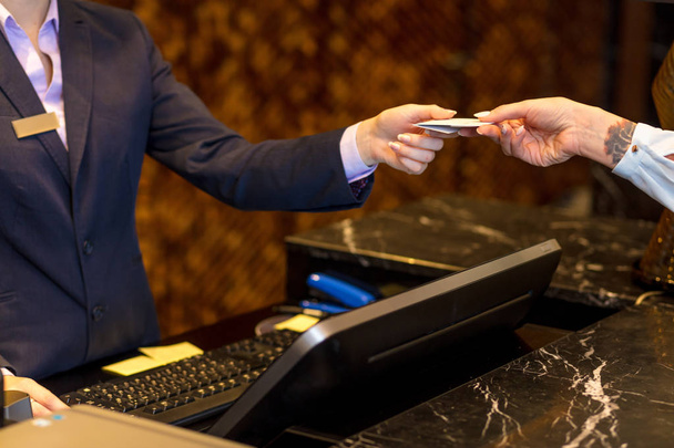 Easy transaction, woman paying with a credit card at hotel reception. - Foto, imagen