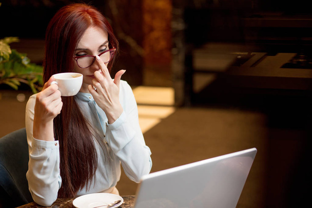 Business woman working at hotel lobby with laptop and drinking coffee - Photo, image