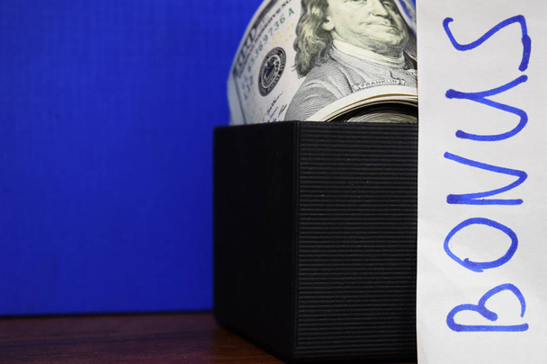 Paquet de dollars dans une boîte cadeau isolée sur fond bleu
 - Photo, image
