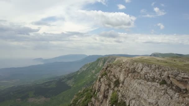 Flight along a cliff in Crimean Mountains. Amazing Aerial view of rocks, forests and sea in Crimea - Footage, Video