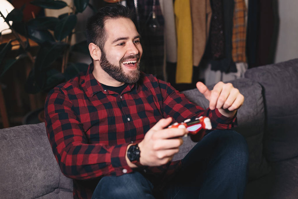 Portrait of a young man gaming, playing video games, winning and celebrating. - Foto, imagen