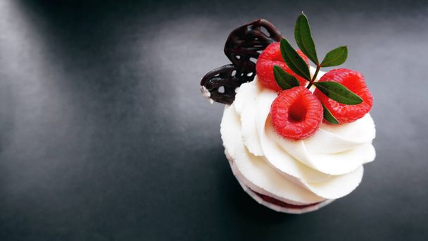 Delicious raspberry cupcakes on dark background - Fotó, kép