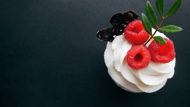 Delicious raspberry cupcakes on dark background - Foto, imagen