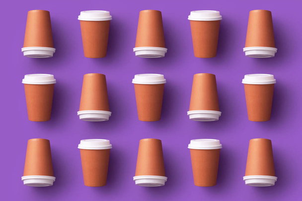 Plusieurs tasses à café jetables organisées sur fond violet
 - Photo, image