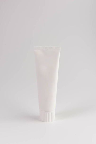 Blank white tube of toothpaste, cream or gel standing on white background. Branding mockup - Fotoğraf, Görsel