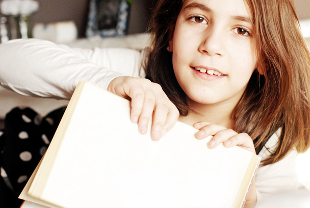 Petite fille pointant du doigt sur un livre vierge avec espace de copie
 - Photo, image