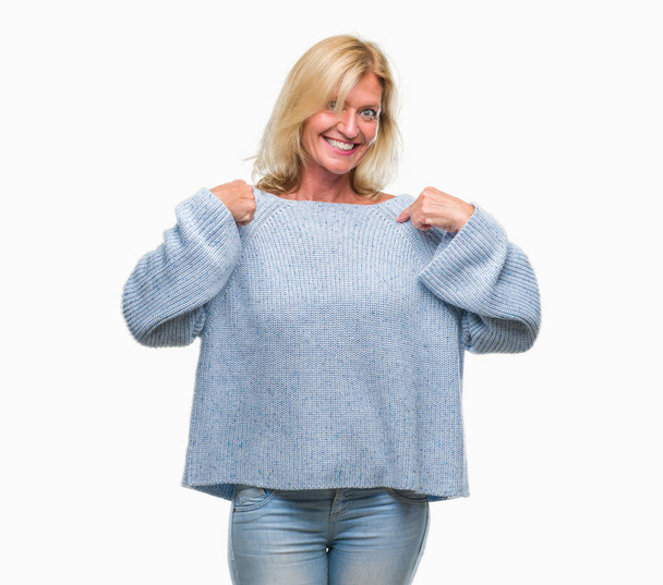 Middle age blonde woman wearing winter sweater over isolated background looking confident with smile on face, pointing oneself with fingers proud and happy. - Foto, immagini