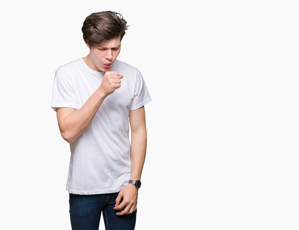 Hombre guapo joven que usa una camiseta blanca casual sobre un fondo aislado sintiéndose mal y tosiendo como síntoma de resfriado o bronquitis. Concepto sanitario
. - Foto, imagen