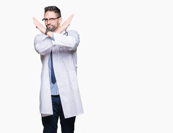 Handsome young doctor man over isolated background Rejection expression crossing arms doing negative sign, angry face - Photo, Image