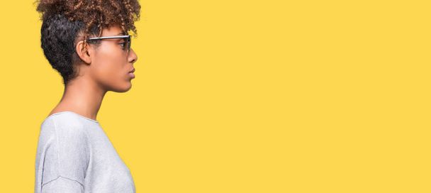 美しい若いアフリカ系アメリカ人女性側を分離の背景にサングラスをかけてリラックス自信を持って笑顔で自然の顔を持つプロファイル ポーズ. - 写真・画像