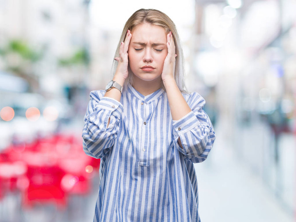 Young blonde woman over isolated background with hand on head for pain in head because stress. Suffering migraine. - 写真・画像