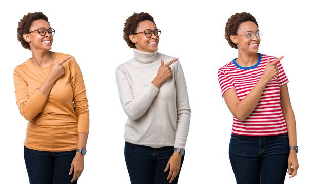 junge afrikanisch-amerikanische Frau mit Afro-Haaren trägt eine Brille fröhlich mit einem Lächeln im Gesicht, das mit der Hand und dem Finger zur Seite zeigt, mit glücklichem und natürlichem Gesichtsausdruck - Foto, Bild