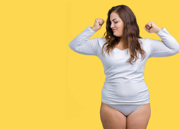 Beautiful plus size young overwight woman wearing white underwear over isolated background showing arms muscles smiling proud. Fitness concept. - Foto, immagini