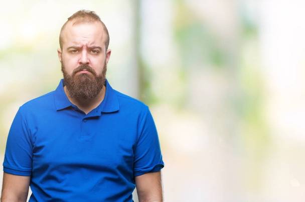 junger kaukasischer Hipster-Mann, der blaues Hemd über isoliertem Hintergrund trägt, deprimiert und beunruhigt, weint wütend und ängstlich. Traurige Miene. - Foto, Bild