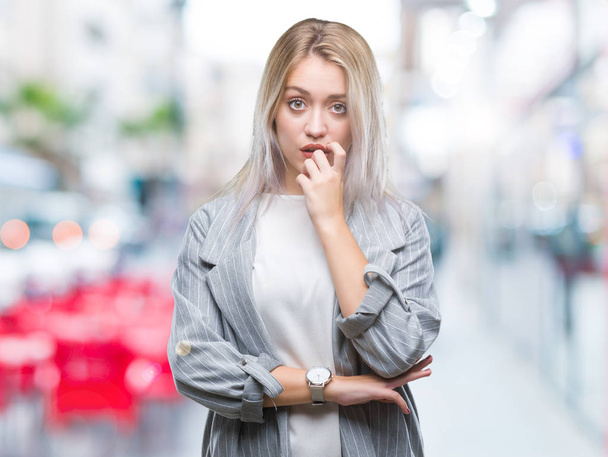 Young blonde business woman wearing jacket over isolated background looking stressed and nervous with hands on mouth biting nails. Anxiety problem. - Photo, Image