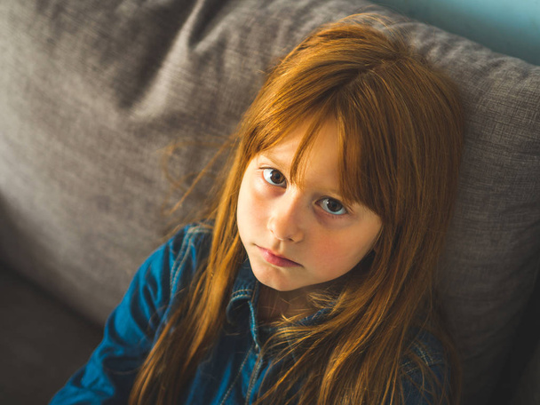 Şirin Kızıl saçlı Görüntüleyicisi ciddi seyir küçük kız. - Fotoğraf, Görsel