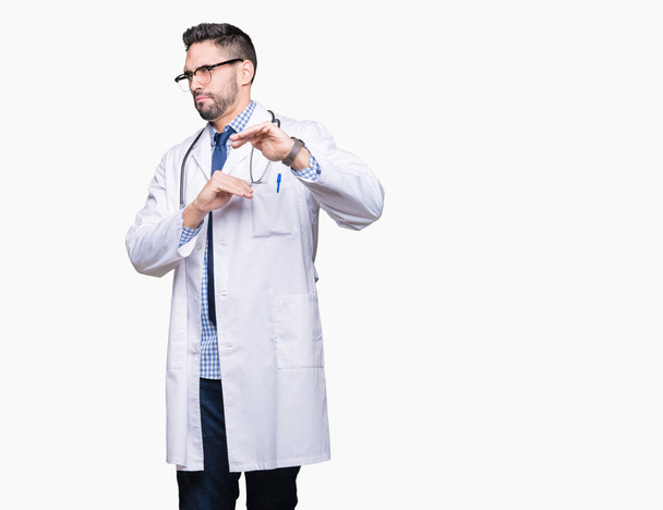 Handsome young doctor man over isolated background disgusted expression, displeased and fearful doing disgust face because aversion reaction. With hands raised. Annoying concept. - Foto, immagini