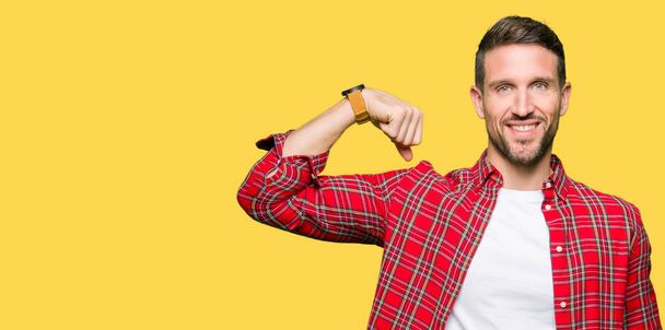 Handsome man wearing casual shirt Strong person showing arm muscle, confident and proud of power - Photo, Image