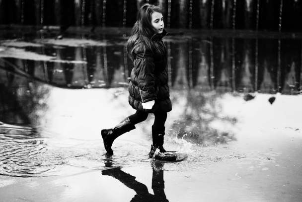 Little girl in a puddle - Фото, изображение