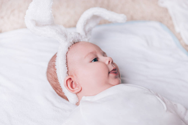 close up.pretty baby in a rabbit suit lying on the bed. - Photo, image