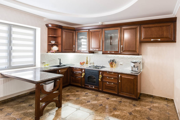 интерьер роскошной кухни с духовкой и деревянными фасадами
 - Фото, изображение