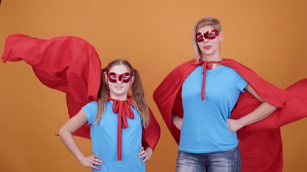 stolze Mutter mit ihrer kleinen Tochter, die sich für Superhelden hält - Filmmaterial, Video