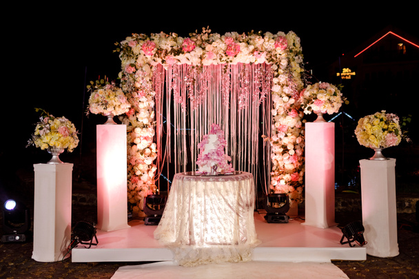 свадебное украшение. Стол со свадебным тортом, свечами, свечами и цветами
. - Фото, изображение