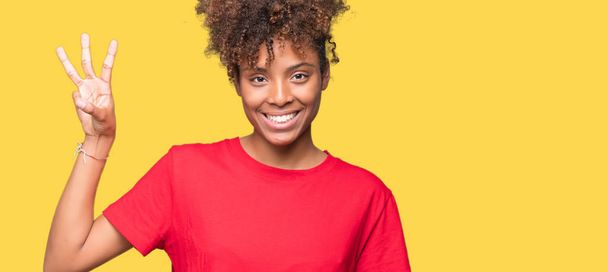 Bella giovane donna afroamericana su sfondo isolato mostrando e indicando con le dita il numero tre sorridendo fiducioso e felice
. - Foto, immagini