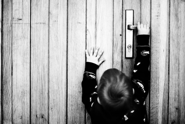 Little boy try to open the door - Фото, изображение