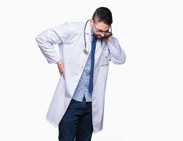 Knappe jonge dokter man over geïsoleerd background lijden van pijn nekletsel, aanraken van nek met hand, spierpijn - Foto, afbeelding