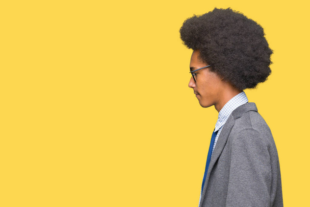 Nuori afrikkalainen amerikkalainen liikemies, jolla on afro-hiukset silmälasit, jotka etsivät sivuun, rentoutua profiili aiheuttaa luonnolliset kasvot luottavaisesti hymyillen
. - Valokuva, kuva