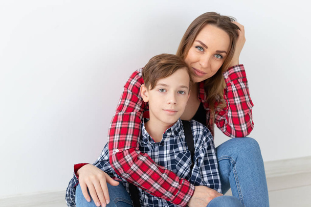 mothers day, children and family concept - cute teen boy with his young mother at home - Φωτογραφία, εικόνα
