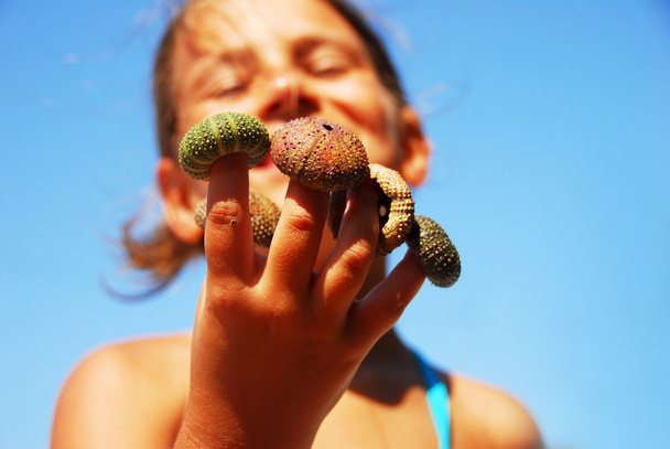 Retrato de niña con concha de erizo de mar
 - Foto, imagen
