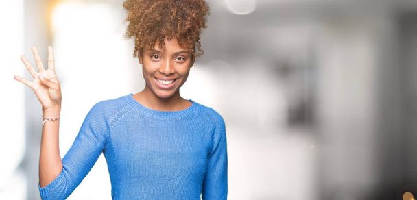 Mooie jonge Afro-Amerikaanse vrouw op geïsoleerde achtergrond weergeven en met de vingers omhoog nummer vier terwijl lacht zelfverzekerd en blij. - Foto, afbeelding