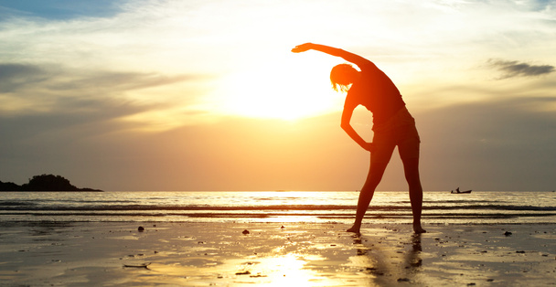 siluet genç kadın, gün batımında sahilde egzersiz. - Fotoğraf, Görsel