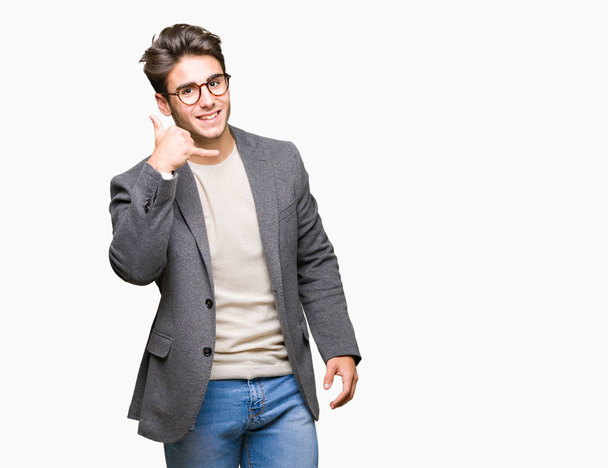 Giovane uomo d'affari con gli occhiali su sfondo isolato sorridente facendo gesto telefonico con le mani e le dita come parlare al telefono. Concetti comunicativi
. - Foto, immagini