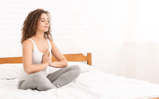 Beyaz kadın yatakta Yoga uygulamak - Fotoğraf, Görsel