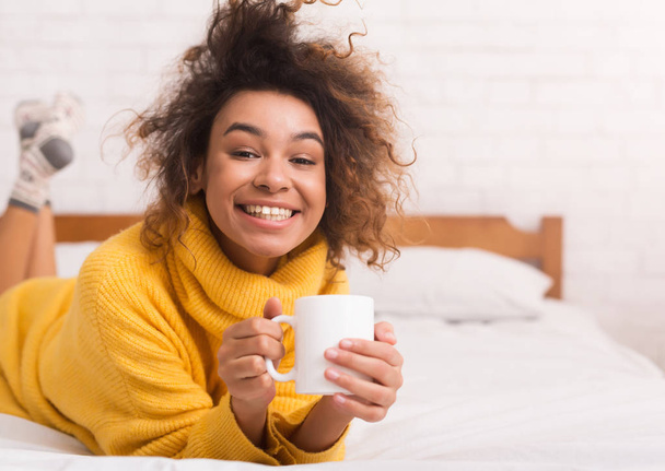 Mulher afro-americana relaxante com xícara de café
 - Foto, Imagem