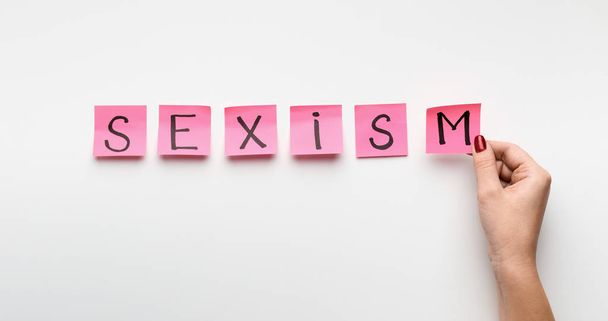 Word SEXISM written on pink office stickers - Foto, Imagem
