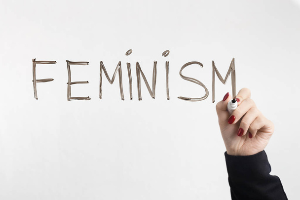 Slovo feminismus na skleněné desce ženských rukou - Fotografie, Obrázek