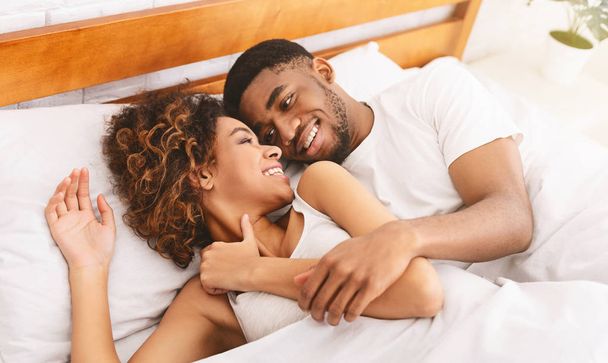 朝は快適なベッドの上でいちゃつく幸せなカップル - 写真・画像