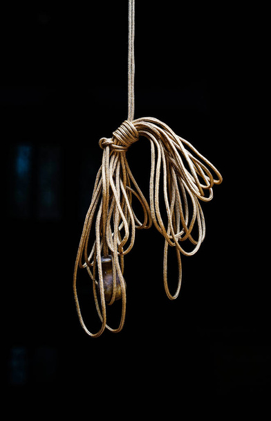 Hanging rope knot on black background. Home related objects. - Photo, Image